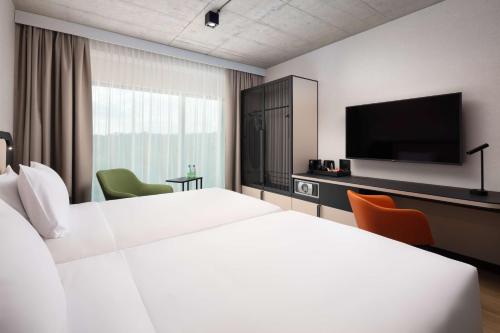 a hotel room with two beds and a flat screen tv at Hyatt Place Krakow in Kraków