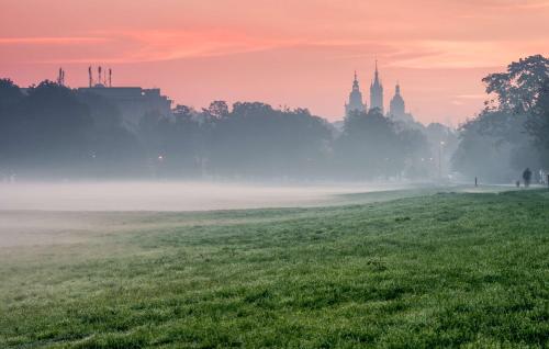 a foggy field with a city in the background at Hyatt Place Krakow in Kraków
