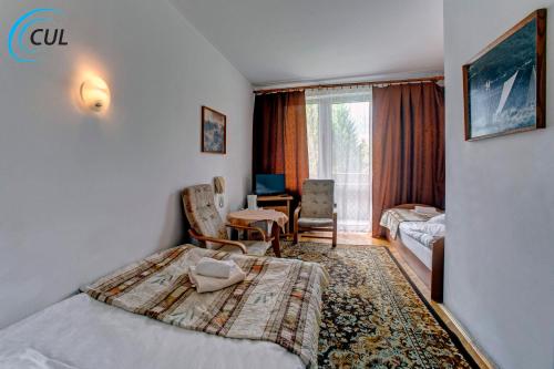 a hotel room with a bed and a living room at Jawor in Polańczyk