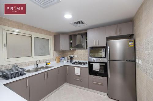 a kitchen with a stainless steel refrigerator and a sink at Prime Select New Giza in Giza