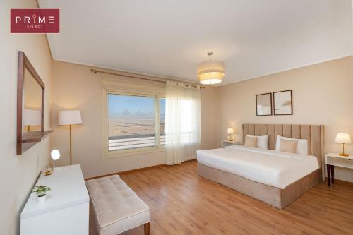 a bedroom with a large white bed and a window at Prime Select New Giza in Giza