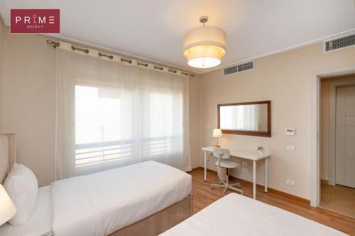 a bedroom with a bed and a desk and a window at Prime Select New Giza in Giza