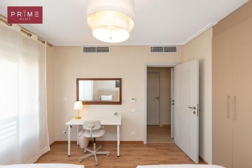 a white room with a desk and a mirror at Prime Select New Giza in Giza