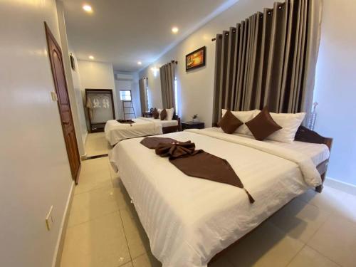 a hotel room with two beds in a room at The Moon Kampot Boutique in Kampot