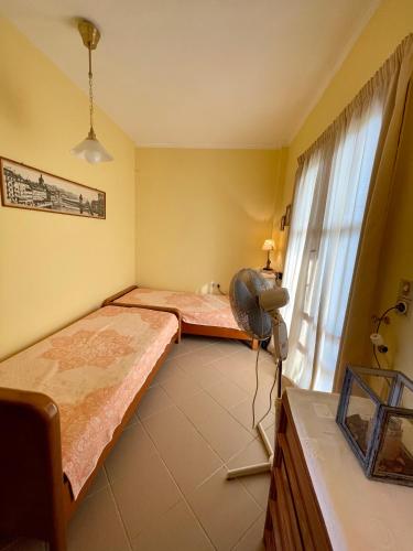 a bedroom with two beds and a window at Lefkandi Family House in Chalkida