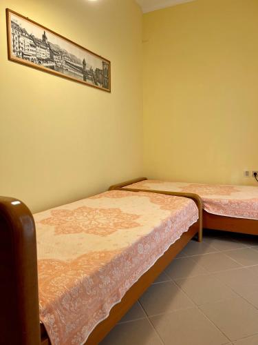 two beds in a room with a picture on the wall at Lefkandi Family House in Chalkida