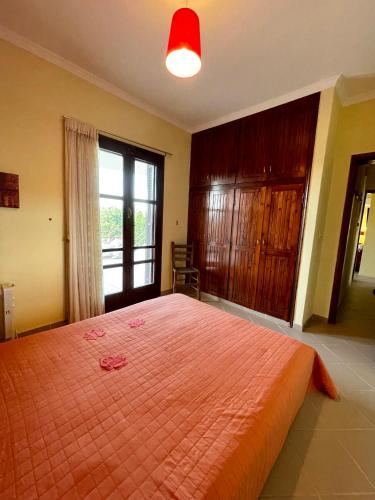 a bedroom with a large orange bed with a window at Lefkandi Family House in Chalkida