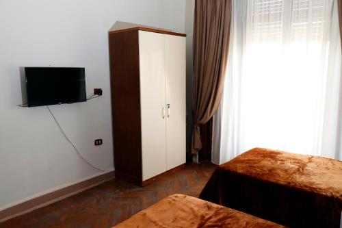 um quarto com uma cama, uma televisão e um armário em Ismailia House Inn no Cairo