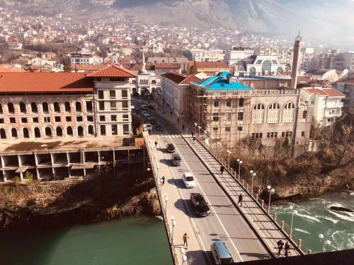 un puente sobre un río en una ciudad con edificios en Hotel Bristol en Mostar