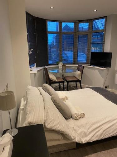 a bedroom with a bed and a table with chairs at Superfast WiFi studio, bathroom & own entrance in Brighton & Hove