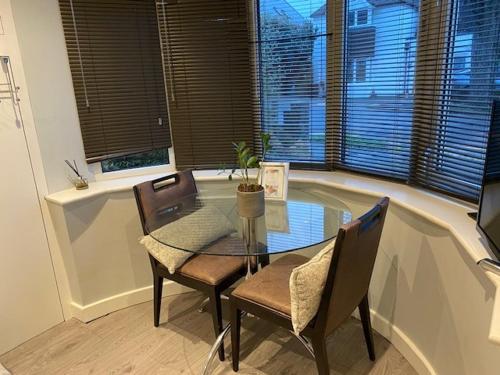 a dining room with a table and chairs and a window at Superfast WiFi studio, bathroom & own entrance in Brighton & Hove