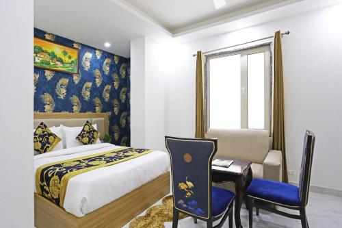 een slaapkamer met een bed, een bureau en een stoel bij Hotel Decent Suites - Delhi Airport in New Delhi