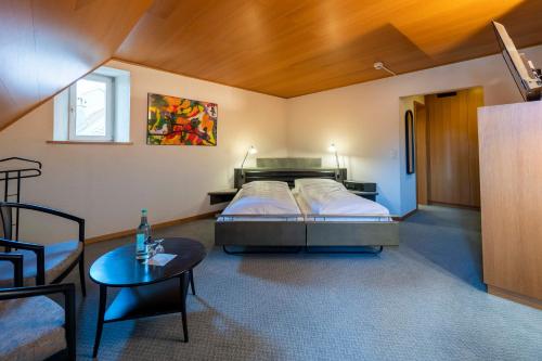 Habitación grande con cama y mesa. en Hotel-Restaurant Krone en Aarberg