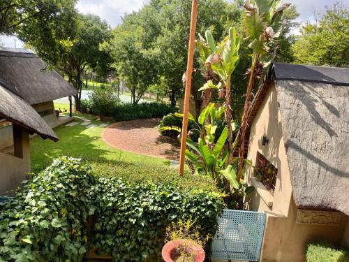 a garden with plants and a building with a fence at Lipizzaner Lodge - Kyalami, Midrand in Kyalami