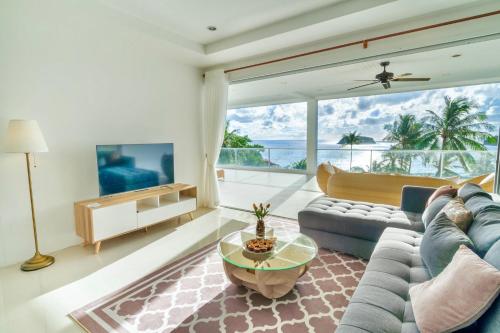 a living room with a couch and a table at Kata Seaview Jacuzzi Suite - Pasifora in Kata Beach