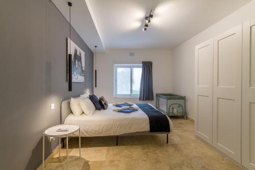 a bedroom with a bed and a window at Wellness Hygge Modern Gozitan Apartment - Happy Rentals in Taʼ Sardina