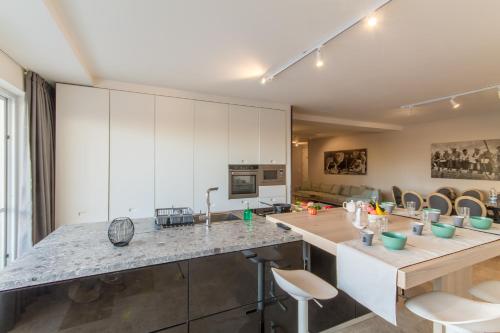 a kitchen with white cabinets and a kitchen island with stools at Wellness Hygge Modern Gozitan Apartment - Happy Rentals in Taʼ Sardina