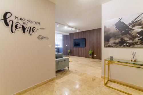 a room with a wall with a sign that reads make yourself at home at Wellness Hygge Modern Gozitan Apartment - Happy Rentals in Taʼ Sardina