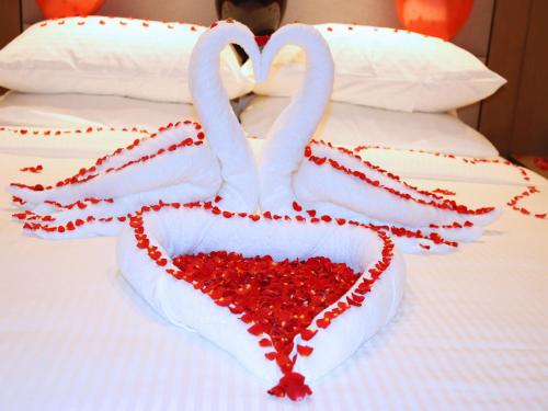 two swans making a heart on a bed at ROZANA HOTEL in Muscat