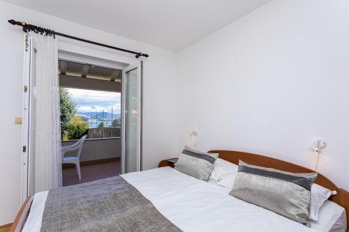 a bedroom with a bed and a sliding glass door at Apartments Crnekovic I Zarok in Ba&scaron;ka