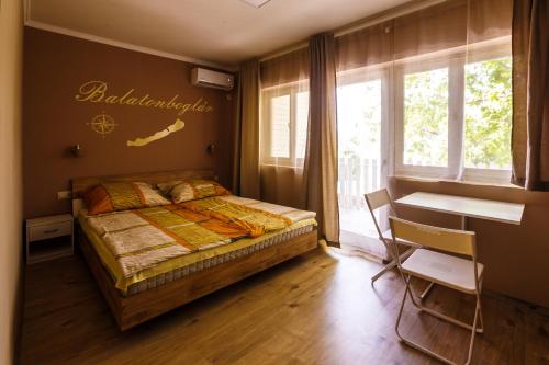 Schlafzimmer mit einem Bett, einem Schreibtisch und einem Fenster in der Unterkunft Mórocz Vendégház in Balatonboglár