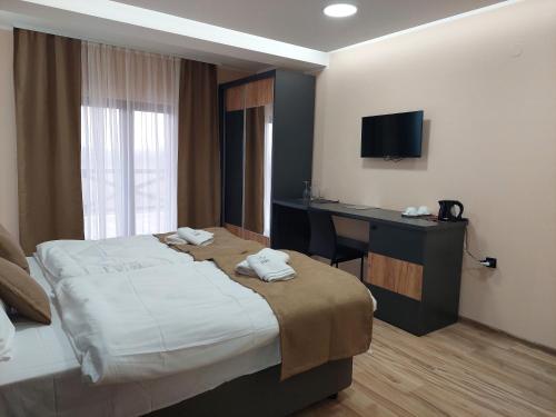 a hotel room with a bed and a desk and a television at Etno Selo Moravski Konaci in Velika Plana