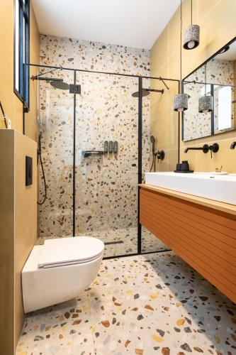 a bathroom with a tub and a toilet and a shower at De Pejoto in Tel Aviv