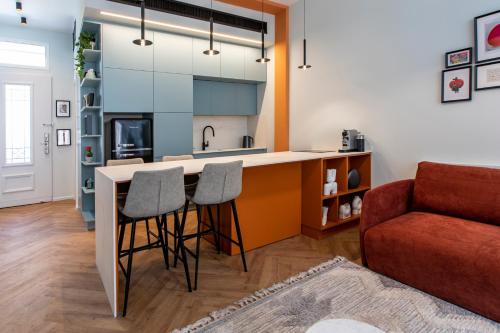 a kitchen with a bar with stools and a couch at De Pejoto in Tel Aviv