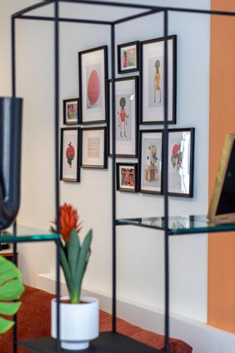 a glass shelf with framed pictures on a wall at De Pejoto in Tel Aviv