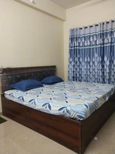 a bedroom with a bed with a blue and white comforter at Swapnapurti Homestay in Alibaug