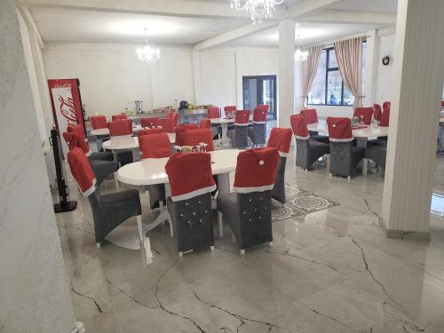 uma sala de jantar com mesas e cadeiras com assentos vermelhos em Soimii Bucovinei Residence em Vatra Moldoviţei