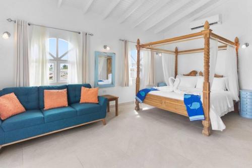 Beach Walk Residences في شاطئ بالم إيغل: غرفة نوم بها سرير مظلة وأريكة زرقاء