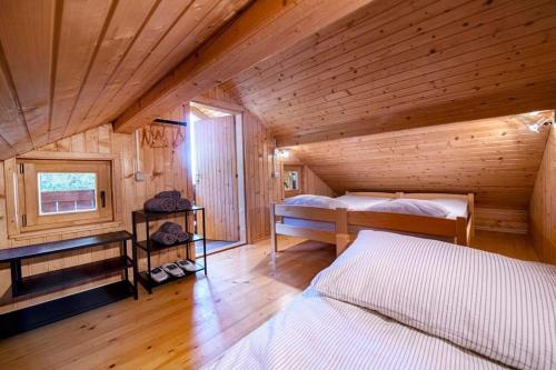 a bedroom with two beds in a wooden cabin at Lunela estate with sauna in Cerklje na Gorenjskem