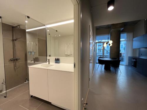 a white bathroom with a sink and a shower at STAY Nordhavn in Copenhagen