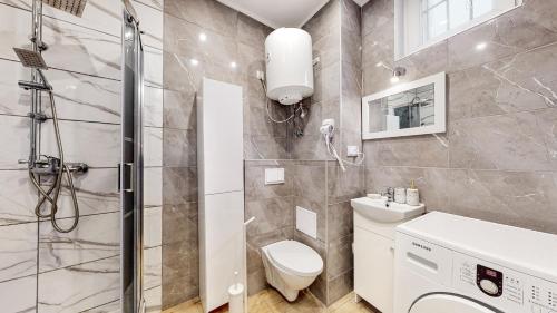 a bathroom with a shower and a toilet and a sink at DUBAI MARINA DE LUX in Bytom