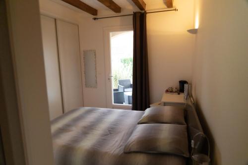 a bedroom with a large bed and a window at La Halte Gourmande in Vachères