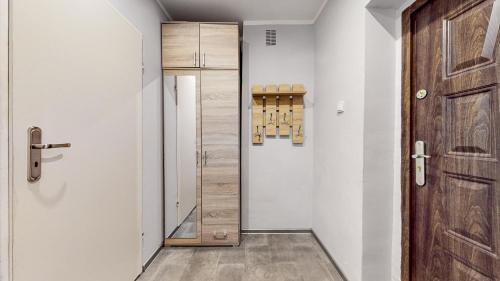 a hallway with a wooden door and a closet at DUBAI MARINA DE LUX in Bytom