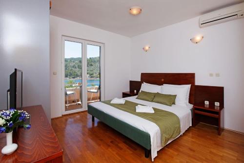 a bedroom with a large bed and a large window at Apartments Vala in Vela Luka