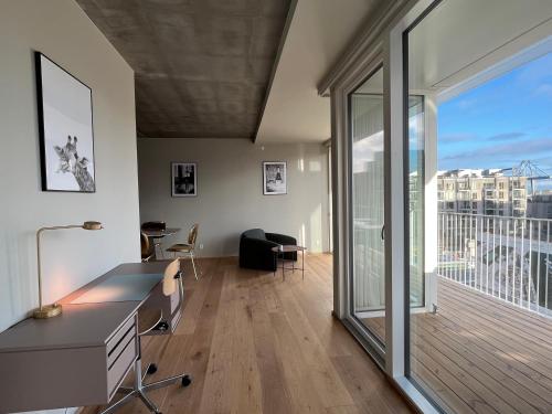 a living room with a desk and a large window at STAY Nordhavn in Copenhagen