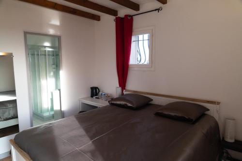 a bedroom with a bed with two pillows on it at La Halte Gourmande in Vachères