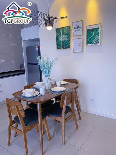 a wooden table and chairs in a kitchen at D'Pristine Design Apartment by TGP in Nusajaya