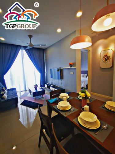 a dining room and living room with a table and chairs at D'Pristine Design Apartment by TGP in Nusajaya