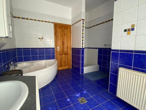 a blue and white bathroom with a tub and a sink at Hermina apartmanház in Budapest