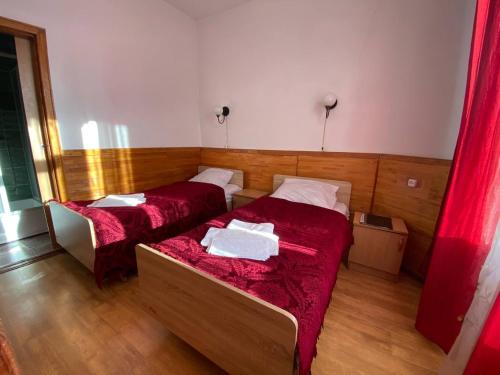 2 Betten in einem Zimmer mit roter Bettwäsche in der Unterkunft Санаторій Червона Калина 