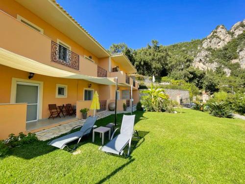 a house with two chairs and a lawn at Villa Amaryllis in Paleokastritsa