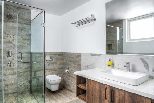 y baño con lavabo y ducha acristalada. en Rainforest Woods, Assagao, Goa - Luxury 4 BHK Private Rooftop Pool en Assagao