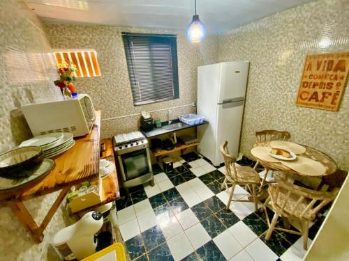 eine Küche mit einem Tisch und einem weißen Kühlschrank in der Unterkunft Pousada Misticasa Fernando de Noronha in Fernando de Noronha