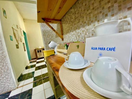 eine Küche mit einem Tisch und weißen Gerichten darauf in der Unterkunft Pousada Misticasa Fernando de Noronha in Fernando de Noronha