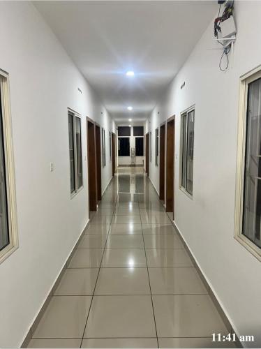 an empty hallway in a building with white walls and windows at LEMER SUITES in Cochin