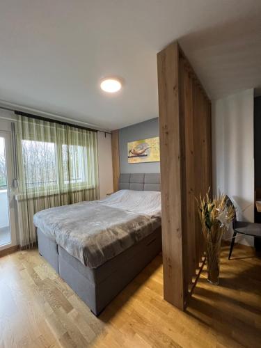 Un dormitorio con una cama con un gran marco de madera en NeNi Apartman, en Vrnjačka Banja